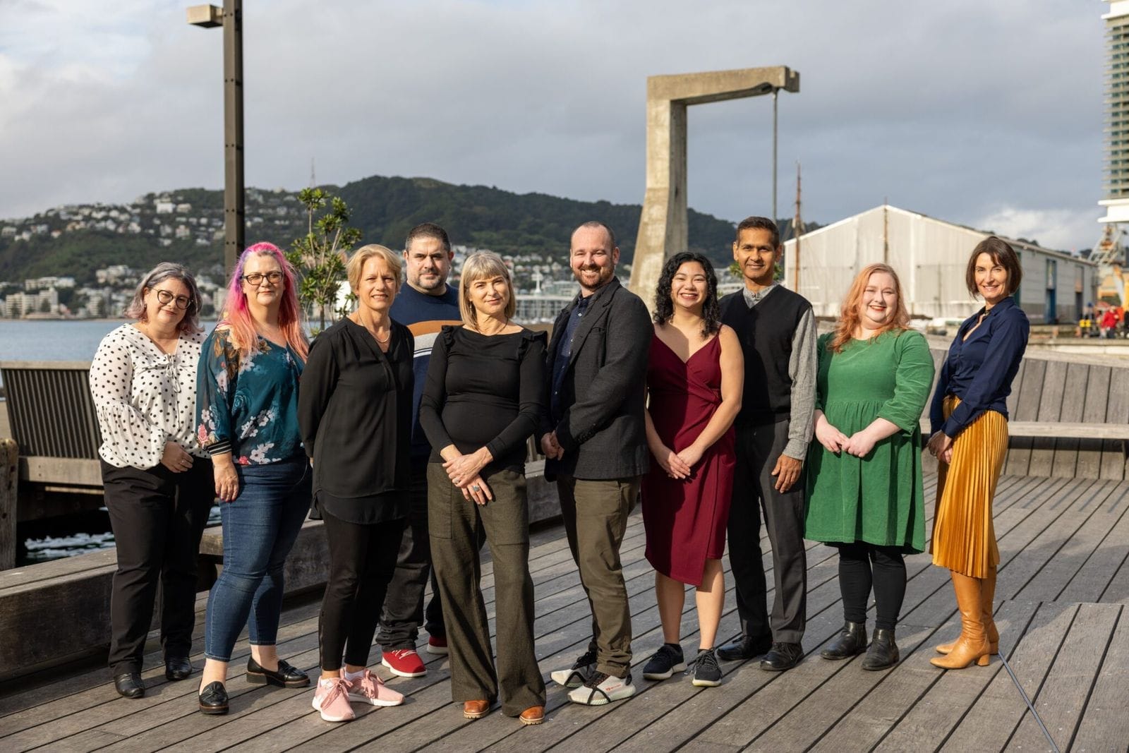 Team of ten colleagues standing together on the Wellington waterfront